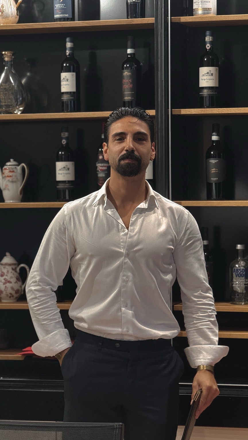 Miguel Herranz, Gründer und Creative Director von Vista, vor einem Weinregal.